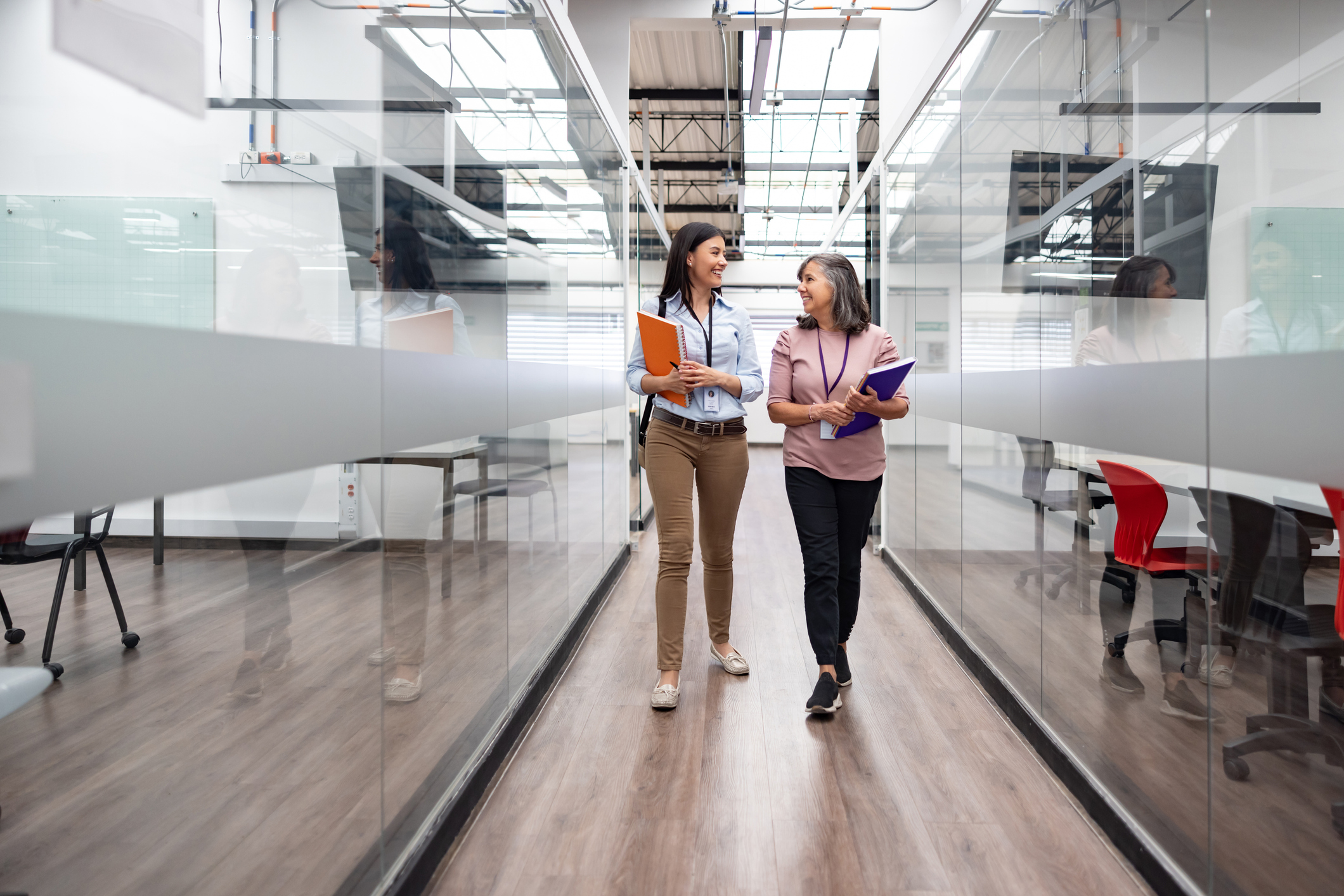 Happy female employees talking in the hall at the office